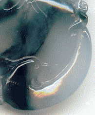 closeup of bird on back of large jade pendant