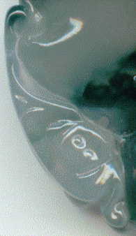closeup of curlicue on back of large jade pendant