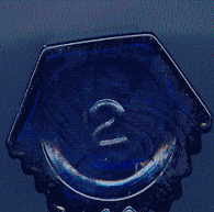 victorian octagonal blue poison bottle: view of base showing raised glass '2' and two ribbed sides.